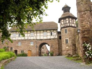 an old stone building with an archway and a tower at Landhaus Hillebrand in Trendelburg
