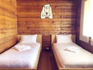two beds in a room with wooden walls at Pieter van Gent Winery & Vineyard in Eurunderee +43 photos