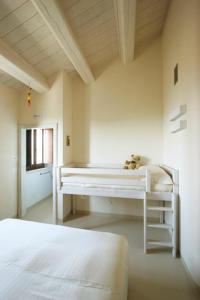 a white bedroom with a bed and a desk at Agriturismo Pozzuolo in Serrungarina