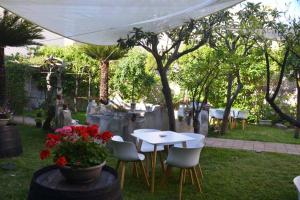 - une table et des chaises sous un parasol blanc dans la cour dans l'établissement Palazzo Ducale Suites, à Monreale