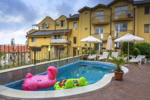 a swimming pool with a inflatablelatable pig in front of a building at Vila Vista Вила Виста in Sveti Vlas