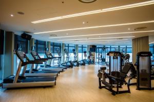 a gym with a row of treadmills and ellipticals at Fullon Hotel Taoyuan Airport Access MRT A8 in Guishan