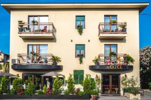 un edificio de hotel con personas sentadas en balcones en B City Hotel, en Bardolino