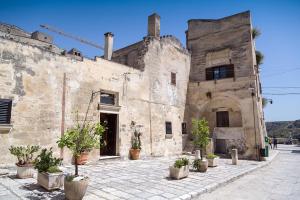 um edifício antigo com vasos de plantas em frente em Umbra Idris Holiday Home em Matera