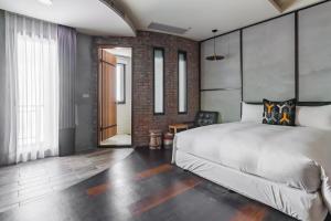 a bedroom with a large bed and a brick wall at Warehouse Inn in Kenting