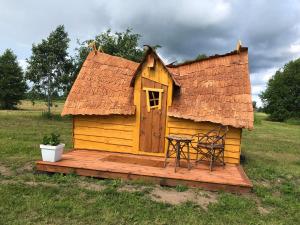 a small house with a table and a chair on a deck at külalistemaja Kadrina mõisa kämpingud in Kadrina