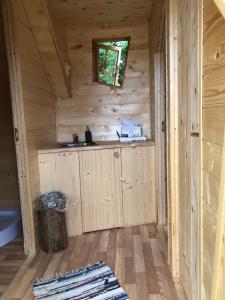 eine Holzhütte mit einem Waschbecken und einem Fenster in der Unterkunft külalistemaja Kadrina mõisa kämpingud in Kadrina