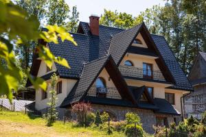 ein Haus mit schwarzem Dach in der Unterkunft Willa Kowala in Groń