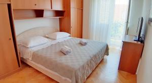 a bedroom with a bed with two towels on it at Makarska Best Buy Apartments in Makarska