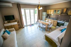 Sweet Home Glikadi في لايميناس: غرفة معيشة مع مطبخ وطاولة مع كراسي