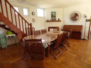 - une salle à manger avec une table et des chaises en bois dans l'établissement Gîte Le Petit Chalet avec parking gratuit, à Étretat
