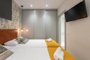 een slaapkamer met 2 bedden en een flatscreen-tv bij Sophisticated brand new flat in Madrid