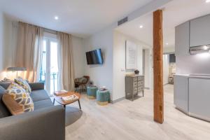 een woonkamer met een bank en een keuken bij Sophisticated brand new flat in Madrid