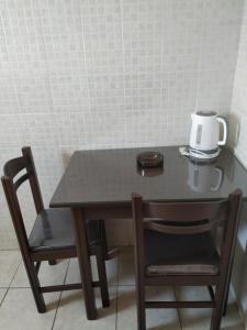 una mesa con dos sillas y una cafetera. en Mavroforos Hotel en Agios Nikolaos