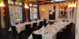 a dining room with white tables and black chairs at Hotel Restaurant Roerdalen in Posterholt