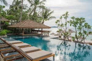a pool at a resort with chairs and umbrellas at Banana Fan Sea Resort in Chaweng