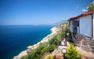 a house on the side of a cliff next to the water at Sunset Villa Hotel in Kaş