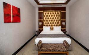 a bedroom with a large bed and a couch at Sapphire Hotel in Baku