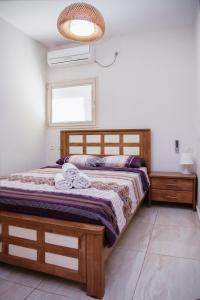 a bedroom with a wooden bed and a window at Apartments4you Dinara in Bat Yam