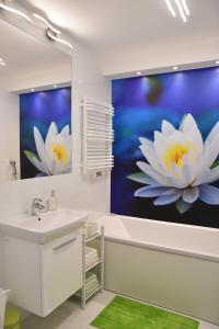 łazienka z dużym obrazem kwiatów na ścianie w obiekcie Natura Apartament w mieście Gdynia