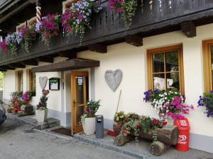 una casa con flores a un lado. en Hotel - Apartment Sonnblick en Heiligenblut