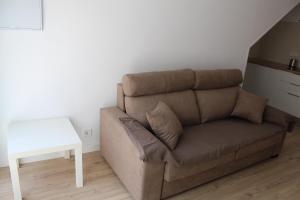Sofá marrón en la sala de estar con mesa en Apartamentos Angelita Plaza Beach, en Málaga