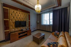 a living room with a couch and a television at Sapphire Hotel in Baku