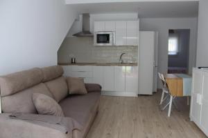 a living room with a couch and a kitchen at Apartamentos Angelita Plaza Beach in Málaga
