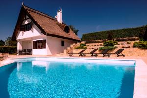 乔保克Perla Balaton的一栋楼前有游泳池的房子