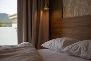 a bed with a wooden headboard and white pillows at Astra Sarti Luxury Suites in Sarti