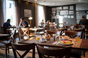 a dining room with tables and chairs with food on them at Panorama Hotel - Free EV Charging Station in Varna City