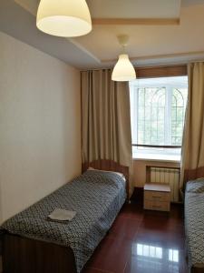 um quarto de hotel com duas camas e uma janela em SPACE Aparts and Rooms em Ecaterimburgo