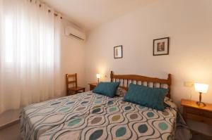 um quarto com uma cama com duas almofadas azuis em Lets Holidays Apartment Tossa Near Beach 2 em Tossa de Mar