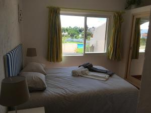 a bedroom with a bed with towels and a window at Vila Paderne - Solar dos Mouros in Porches
