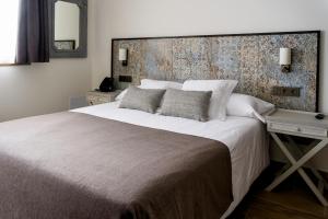 A bed or beds in a room at Sa Voga Hotel & Spa