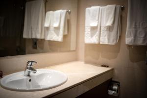 a bathroom with a sink and a mirror and towels at Panorama Hotel - Free EV Charging Station in Varna City
