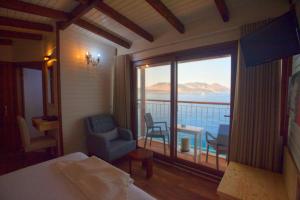 a bedroom with a balcony with a view of the ocean at Sunset Villa Hotel in Kaş