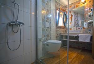 a bathroom with a shower and a toilet and a sink at Sunset Villa Hotel in Kaş