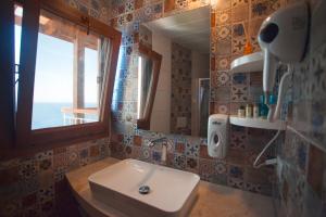 a bathroom with a sink and a mirror and a window at Sunset Villa Hotel in Kaş