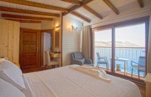 a bedroom with a bed and a view of the ocean at Sunset Villa Hotel in Kaş