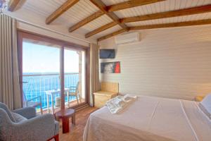 a bedroom with a bed and a large window at Sunset Villa Hotel in Kaş