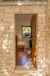 an open door into a room with a stone wall at DVORAC “KAŠTIL JELA” in Milna