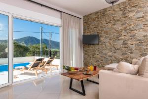 a living room with a stone wall at Arsenoi's Pool Villa in Skala Potamias