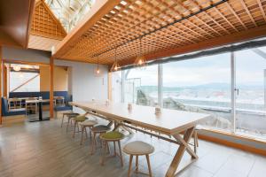 ein großer Tisch und Stühle in einem Zimmer mit einem großen Fenster in der Unterkunft Hotel Wing International Asahikawa Ekimae in Asahikawa