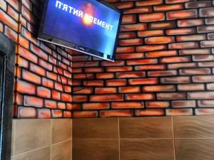 a tv hanging on a brick wall with a television at Yourhostel Университет in Kyiv
