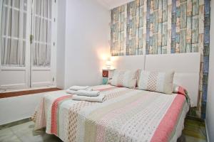 1 dormitorio con 1 cama con 2 toallas en Apartamento MONÍSIMO en el corazón de CÁDIZ, en Cádiz