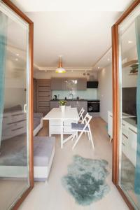 kuchnia i salon z białym stołem i krzesłami w obiekcie Apartament słoneczny w Polanicy Zdroju
