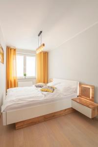 sypialnia z dużym białym łóżkiem i oknem w obiekcie Apartament słoneczny w Polanicy Zdroju
