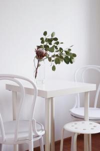 uma mesa branca com um vaso com uma planta em Pokoje Łebska 24 em Leba