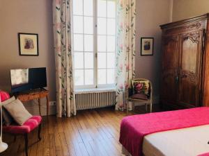 a bedroom with a bed and a large window at Le Donjon d'Anthon in Anthon